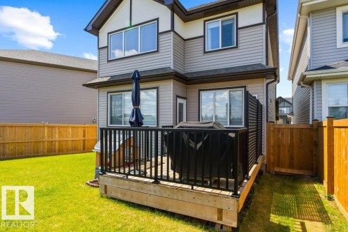 Rear exterior featuring a wood deck with black metal railing - 25 Nettle Crescent, St. Albert, AB 