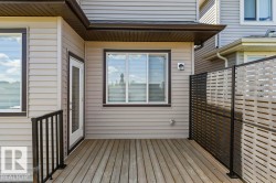 Rear deck with wood-finish flooring and black metal railing - 