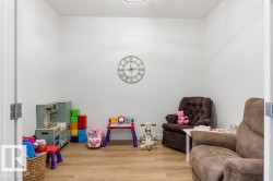 Versatile interior room featuring light wood-finish flooring, white wall paint, and a flush-mounted ceiling light fixture - 