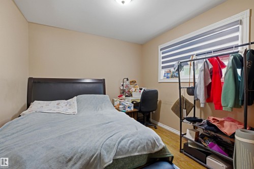 Bedroom featuring wood-finish flooring, a window with horizontal blinds, and neutral wall paint - 8911 169 Street Nw, Edmonton, AB 