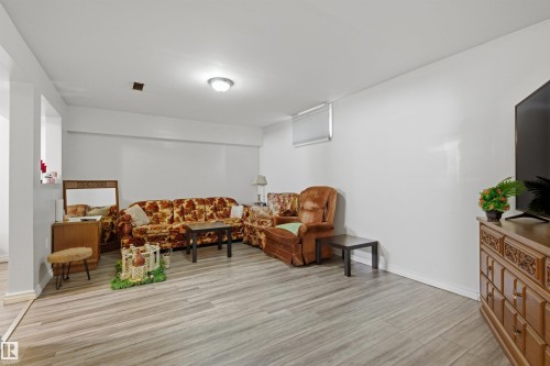 Lower-level room featuring wood-finish flooring, recessed lighting, and a window - 8911 169 Street Nw, Edmonton, AB 