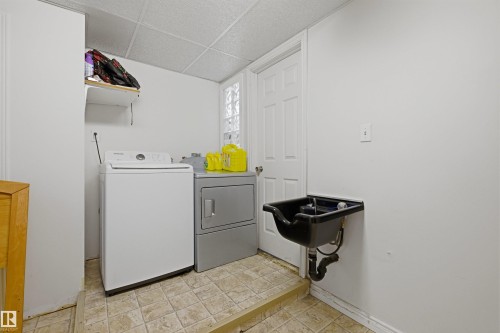 Dedicated laundry area featuring a utility sink, tiled flooring, and a drop ceiling - 8911 169 Street Nw, Edmonton, AB 