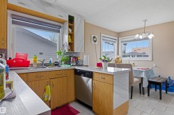 Kitchen and dining area featuring a double basin stainless steel sink, wood-finish cabinetry, light-toned countertops, and tiled flooring - 