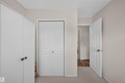 Built-in wardrobe with contemporary hardware, light-colored walls, and textured carpet - 