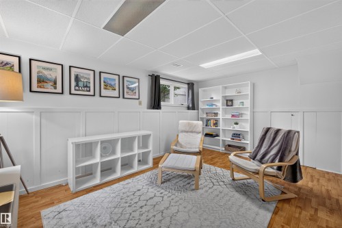 Finished lower level featuring a drop ceiling with recessed lighting, wood-finish flooring, white wainscoting - 244 Knottwood Road N, Edmonton, AB 