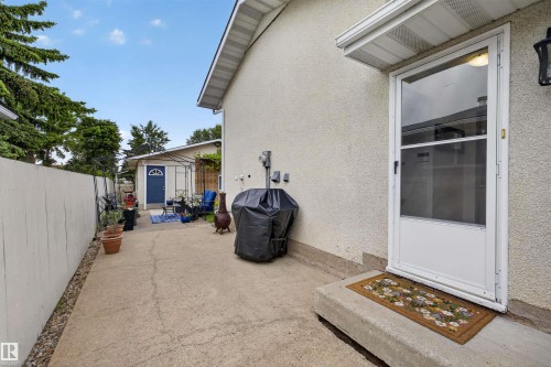 Private side patio with concrete surfacing, offering direct exterior access - 244 Knottwood Road N, Edmonton, AB 