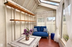 Sunroom featuring wood-finish flooring, a skylight, and large window panels - 