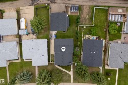 Aerial view showcasing a residential property with a dark shingle roof - 