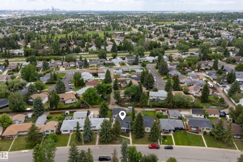 Aerial perspective of a residential street featuring a single-family dwelling with a dark shingled roof and light gray siding - 244 Knottwood Road N, Edmonton, AB 