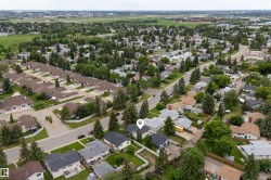 Neighborhood aerial featuring established residential streets with mature trees and green spaces - 