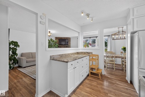 Functional kitchen with white cabinetry and wood-finish flooring - 244 Knottwood Road N, Edmonton, AB 