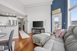 Open-concept living area with high ceilings and wood-finish flooring - 