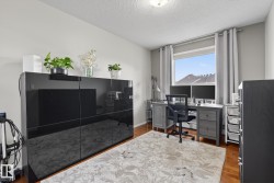 Room featuring wood-finish flooring, a window with grey curtains, and neutral wall paint - 