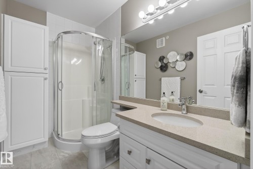 Bathroom featuring a white vanity with an undermount sink, a light-toned countertop, and a chrome faucet - 421 9730 174 Street, Edmonton, AB 