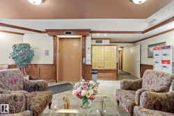 Lobby area featuring an elevator, wood paneling, wall-mounted mailboxes, and parcel lockers - 