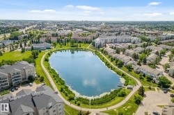 Aerial perspective showcasing a central lake surrounded by residential properties and green spaces - 