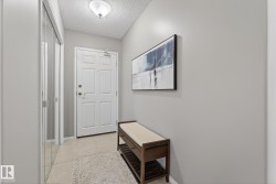 Entryway featuring a paneled door with brass hardware, tile flooring, and mirrored closet doors - 