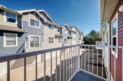 Private balcony with white metal railing, offering exterior building views - 