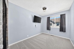 Bedroom featuring light blue walls, gray carpeting, and a window with white trim - 