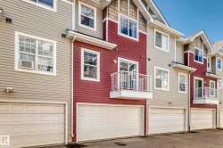 Multi-story townhomes featuring horizontal siding in varied tones, gabled roofs, and individual garage doors - 