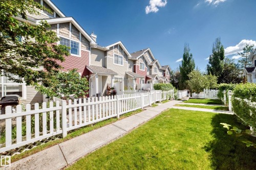Townhome exterior featuring varied siding materials, gabled rooflines, and individual covered entrances - 146 5604 199 Street, Edmonton, AB 