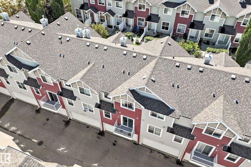 Multi-story townhomes featuring asphalt shingle roofing, attached garages, and private balconies - 146 5604 199 Street, Edmonton, AB 