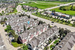Aerial perspective showcasing a community of multi-story townhomes with pitched roofs - 