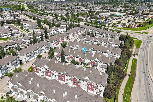 Aerial perspective showcasing a community of multi-story townhomes with varying exterior colors - 146 5604 199 Street, Edmonton, AB 