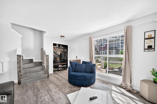 Living area featuring wood-finish flooring and a large picture window - 146 5604 199 Street, Edmonton, AB 