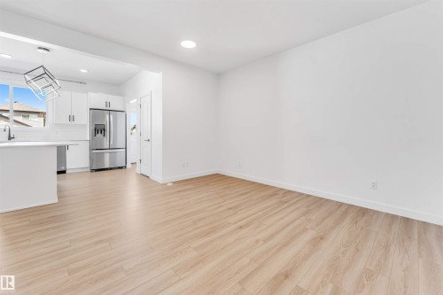 Open-concept living space featuring wood-finish flooring - 1208 14 Ave Nw, Edmonton, AB 