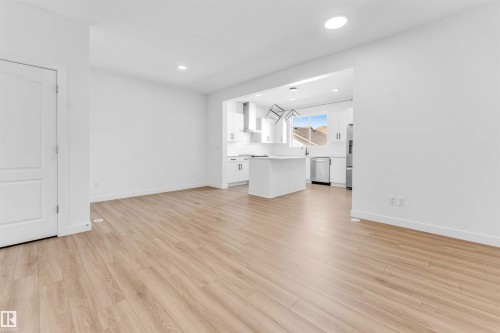Spacious room featuring light wood-finish flooring and recessed lighting - 1208 14 Ave Nw, Edmonton, AB 