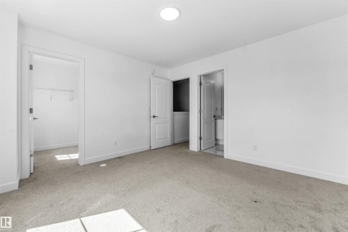 Carpeted room with white walls, recessed ceiling lighting, and crisp white trim - 1208 14 Ave Nw, Edmonton, AB 