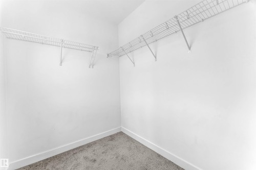 Walk-in closet with wire shelving, white walls, and carpeting - 1208 14 Ave Nw, Edmonton, AB 