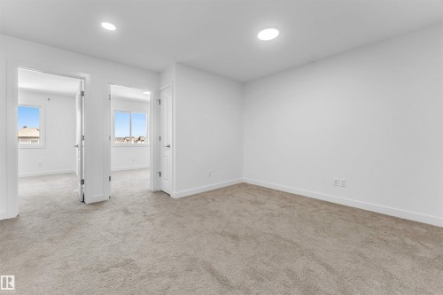 Spacious room featuring neutral carpet flooring and recessed ceiling lighting - 1208 14 Ave Nw, Edmonton, AB 