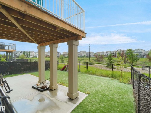 Covered concrete patio with overhead wood deck structure and baluster railing - 4615 175 Avenue, Edmonton, AB 