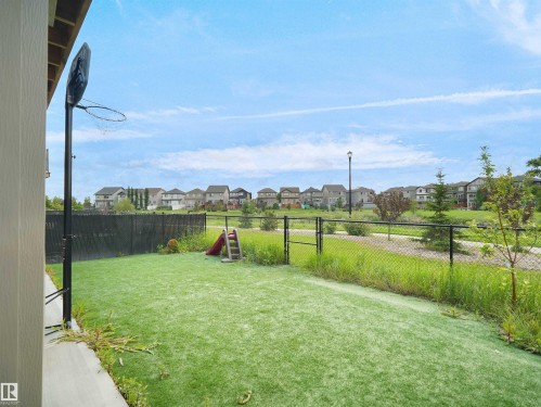 Expansive fenced yard featuring artificial turf and a basketball hoop - 4615 175 Avenue, Edmonton, AB 