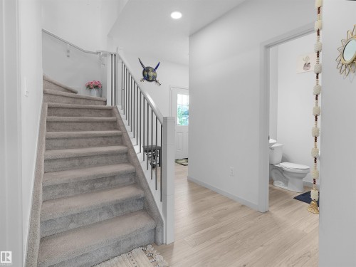 Light-toned wood-finish flooring complements the white walls and trim - 4615 175 Avenue, Edmonton, AB 
