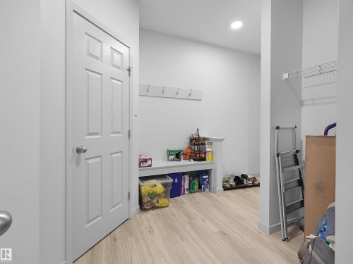 Utility area featuring light wood-finish flooring, recessed lighting, and a built-in storage bench with an integrated coat rack - 4615 175 Avenue, Edmonton, AB 