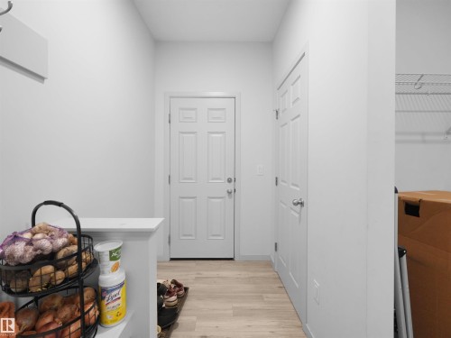 Entryway featuring a panel door, light-toned wood-finish flooring, and white walls - 4615 175 Avenue, Edmonton, AB 