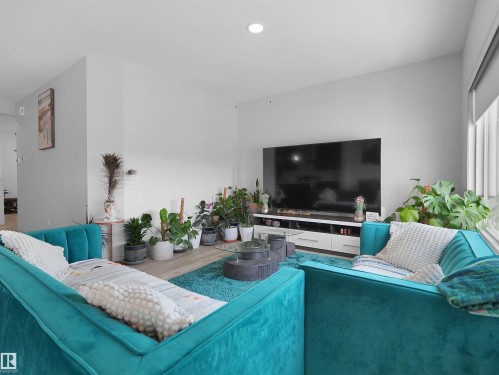 Living space featuring wood-finish flooring, recessed lighting, and a white entertainment console - 4615 175 Avenue, Edmonton, AB 