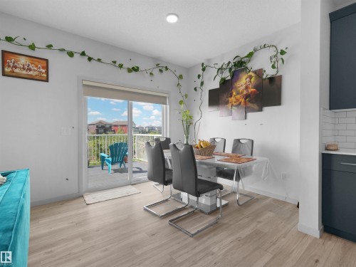 Light wood-finish flooring extending from the living space into the kitchen area - 4615 175 Avenue, Edmonton, AB 