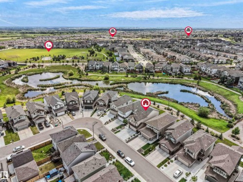 Aerial perspective showcasing a residential community with numerous detached homes, surrounded by green spaces and multiple water features - 4615 175 Avenue, Edmonton, AB 