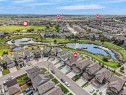 Aerial perspective showcasing a residential community with numerous detached homes, surrounded by green spaces and multiple water features - 4615 175 Avenue, Edmonton, AB 