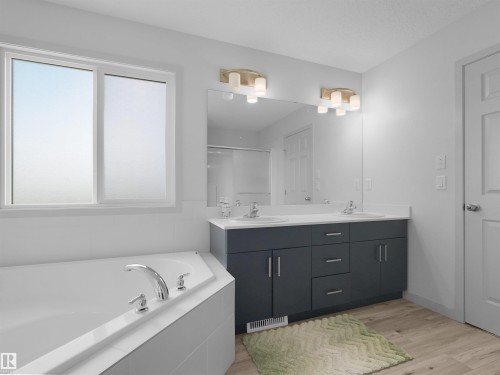 Bathroom featuring a built-in corner soaking tub, a double vanity with dark cabinetry, white countertops, and two wall-mounted light fixtures - 4615 175 Avenue, Edmonton, AB 