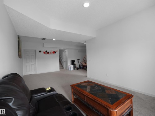 Spacious lower-level room featuring light gray carpeting, recessed lighting, and white trim - 4615 175 Avenue, Edmonton, AB 