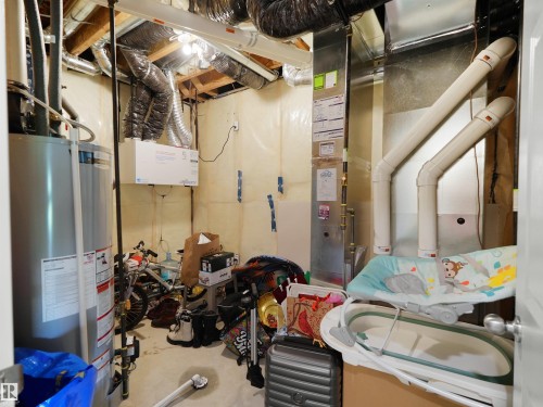 Utility area featuring a water heater, HVAC system with exposed ductwork, and an air exchanger unit - 4615 175 Avenue, Edmonton, AB 