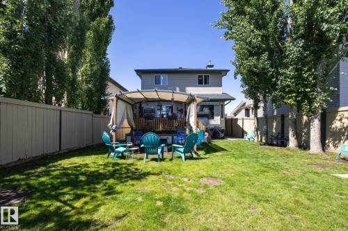 Expansive backyard featuring a manicured lawn and mature trees - 60 Leyland Way, Spruce Grove, AB 
