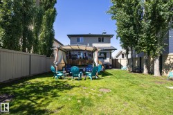 Expansive backyard featuring a manicured lawn and mature trees - 
