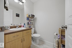Bathroom vanity with a wood-finish cabinet, integrated sink, and dark countertop - 