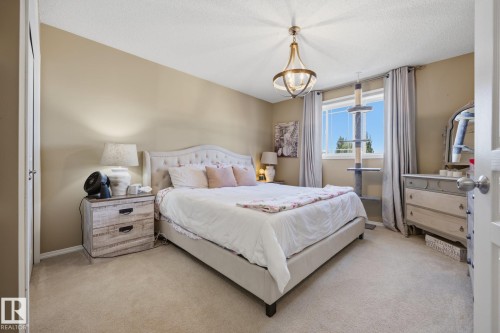 Bedroom featuring carpeted flooring and a white paneled door - 60 Leyland Way, Spruce Grove, AB 